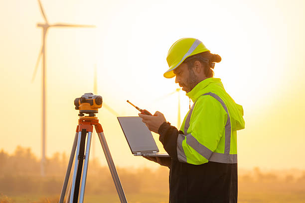 istock Engineer working on laptop checking wind turbines of the field. 2204250647