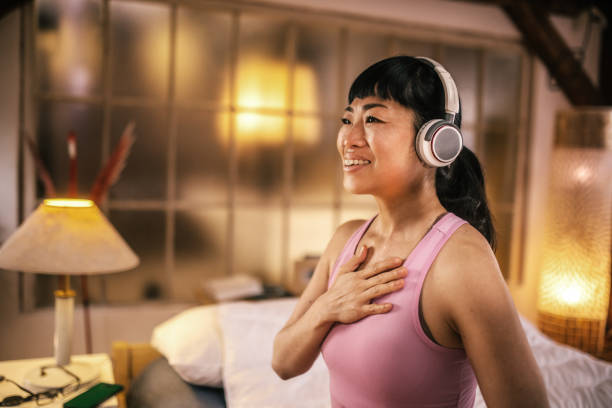 istock Young  japanese Woman Practicing Breathing Exercise At Home 2204256515