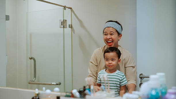 istock Mother and son looking at mirror in bathroom 2204256727