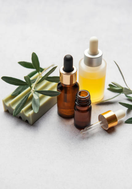 istock Natural olive oil cosmetic products with olive tree branch on grey table 2204257307