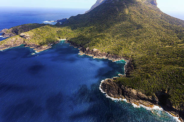 A stunning aerial view of Lord Howe Island’s turquoise waters, rugged coastline, and lush volcanic cliffs in Australia