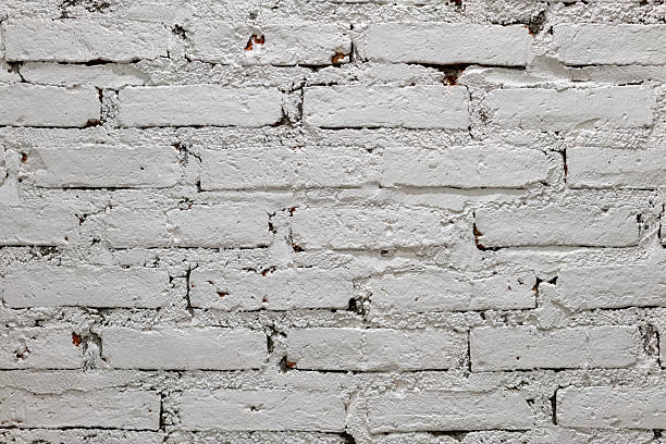 istock A close-up shot of a white painted brick wall with visible mortar and a slightly distressed texture. 2204262872