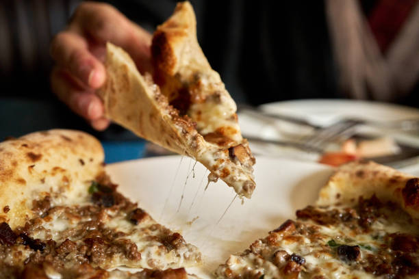 istock Hand picking up a slice of pizza 2204263059