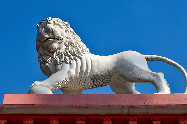 istock The image features a majestic white lion statue atop a red and beige structure against a vibrant blue sky. 2204263704