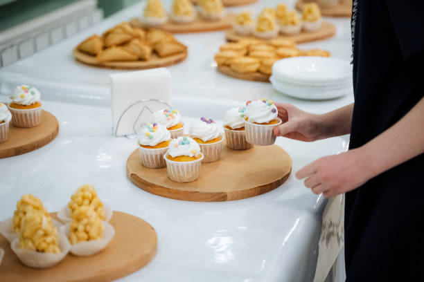 istock A person is reaching out to take a delicious cupcake from an inviting buffet table filled with various tempting treats and desserts, showcasing their choice for a sweet snack today 2204266229