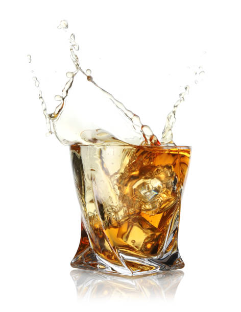 istock Whiskey splashing out of glass on white background 2204267519