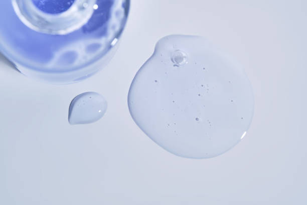 istock Cosmetic bottle and a drop of serum on a white background. 2204267919