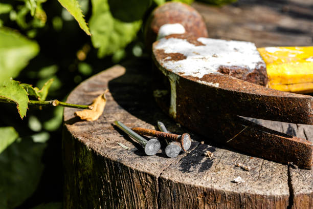 istock Rusty Hammer and Nails on Wooden Stump. Rusty Hand Tools and Nails on a Wooden Surface 2204267924