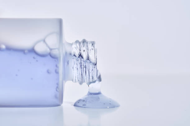 istock A cosmetic bottle from which a blue emulsion is poured. 2204268163