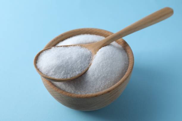 istock Organic white salt in bowl and spoon on light blue background, closeup 2204268834