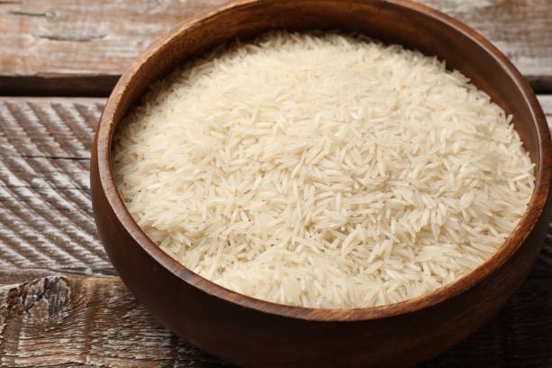 istock Raw basmati rice in bowl on wooden table, closeup 2204270473