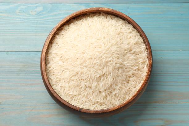 istock Raw basmati rice in bowl on light blue wooden table, top view 2204270507