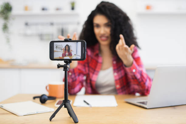 istock Woman recording a video in kitchen using smartphone on tripod setup 2204271284