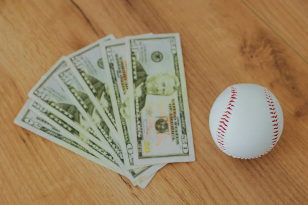 istock Baseball with dollar banknotes. Lockout, gambling concept. 2204272182