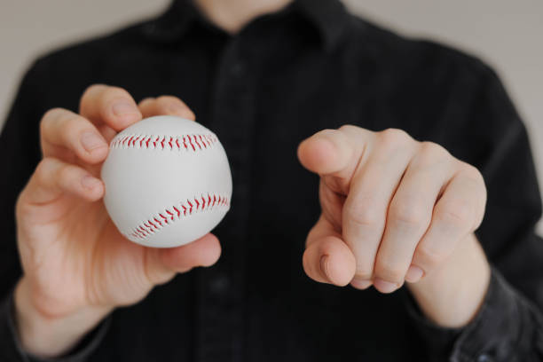 istock Man holding baseball and pointing his finger to the camera close up 2204272183