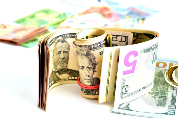 American currency, dollars, of various denominations lie chaotically on the table.