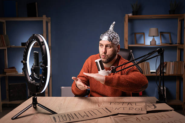 istock Crazy conspiracy theorist blogger streaming live at home using smartphone and ring light, passionately gesturing showing measure size gesture with hands 2204276171