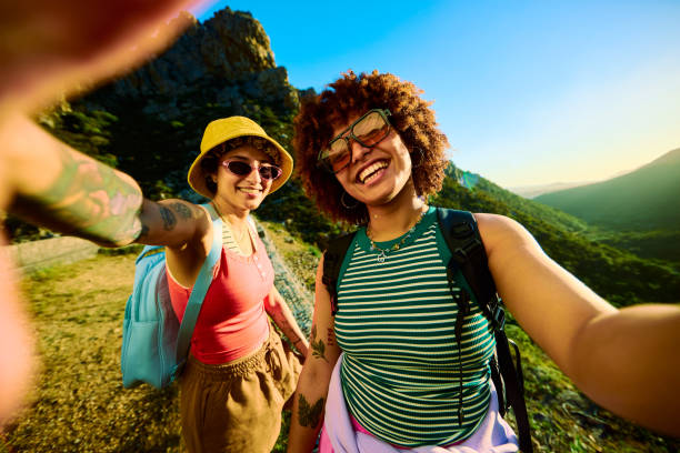 istock Two smiling female tourists taking a selfie while hiking in the mountains 2204276608
