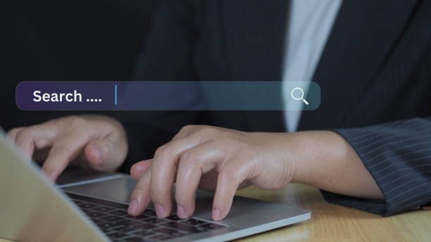 istock Businessman using computer laptop with search bar icon for browsing information network and SEO or search engine optimization concept. 2204276770