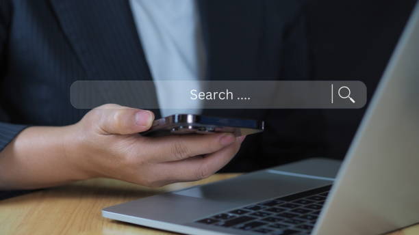 istock Businessman using computer laptop with search bar icon for browsing information network and SEO or search engine optimization concept. 2204276786