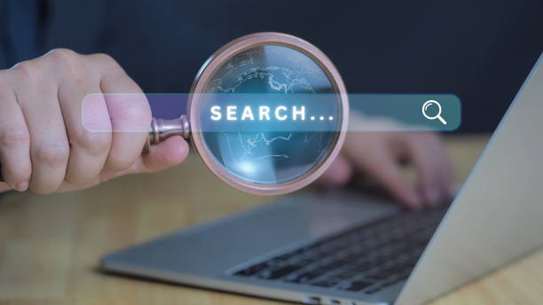 istock Marketing searching business and web browser data trend concept.Businessman hold magnifier glass and use computer keyboard for search engine optimization or SEO. 2204276794