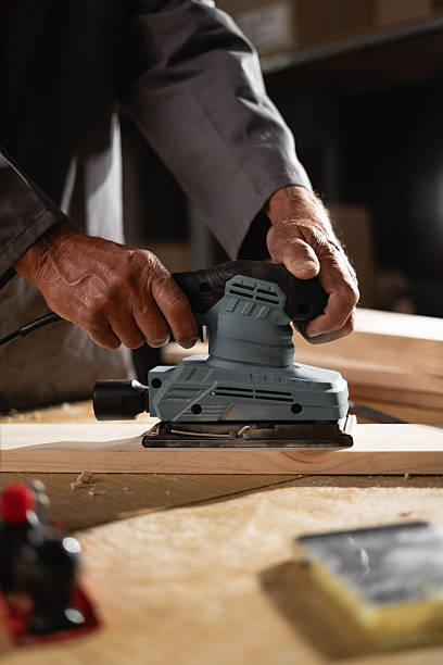 istock Senior carpenter sanding a wood with sander machine at workshop 2204276904