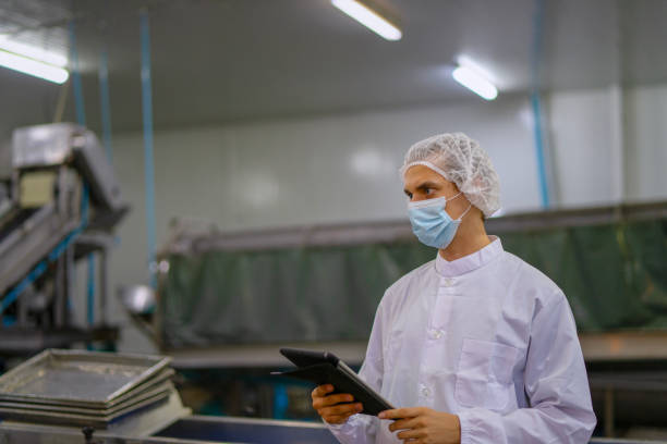 istock Employee working at canned fish factory. 2204277871