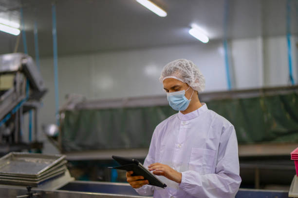 istock Employee working at canned fish factory. 2204277878