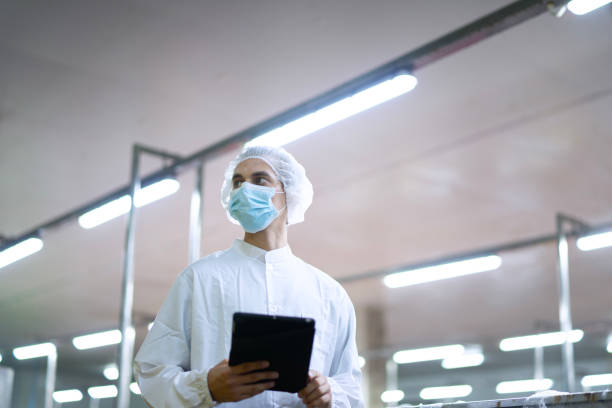 istock Employee working at canned fish factory. 2204277943