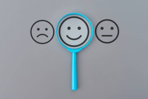 istock A blue magnifying glass with a happy face emoticon visible through the lens. 2204278752