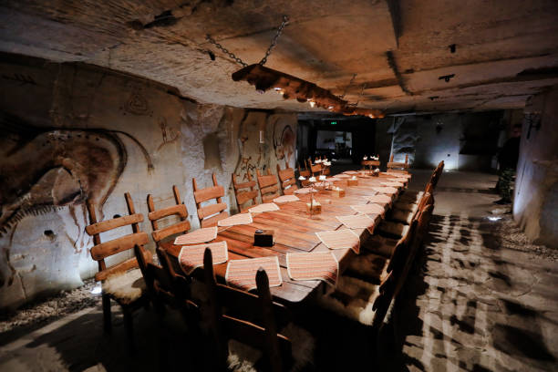 istock Chic underground dining with rustic wood tables and cave art in a historic setting 2204278795