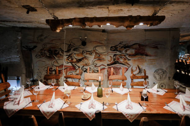 istock Rustic dinner setting with cave paintings, wooden decor, and warm lighting 2204278817