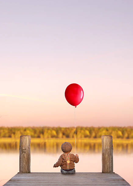 istock cute toddler boy with the red balloon 2204279265