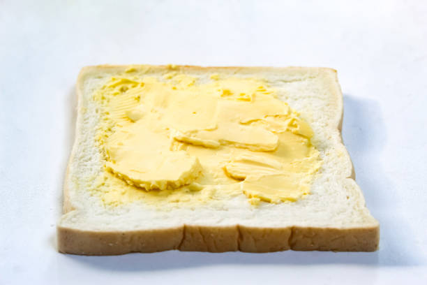 white bread with margarine spread isolated on white background