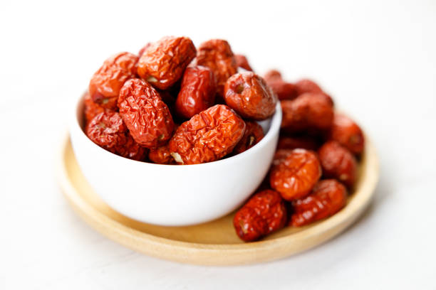 Dried jujube or Dried red Chinese dates, seedless on wooden background. Closeup.