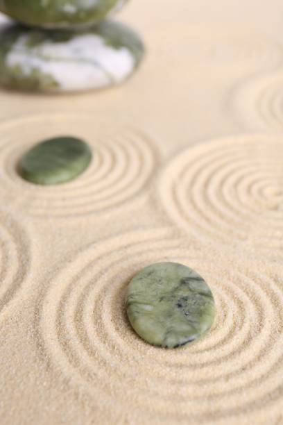 istock Zen garden stones on beige sand with pattern 2204286539