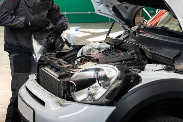 istock Serviceman repair headlight in car service. 2204287127