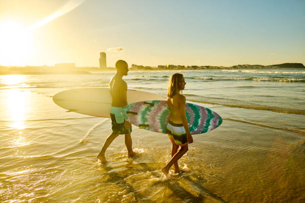 istock Father and son carrying surfboards on Australian beach during holiday 2204287143