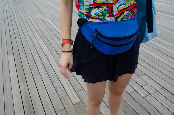 Girl with bum bag with a wooden floor on the background.