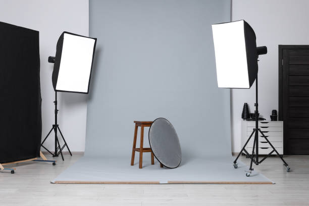 istock Stool with light reflector surrounded by professional lighting equipment in photo studio 2204287812