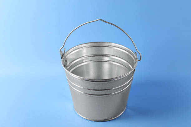 istock One shiny metal bucket on light blue background 2204287837