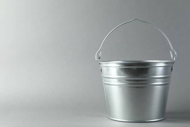 istock One shiny metal bucket on light grey background. Space for text 2204287854