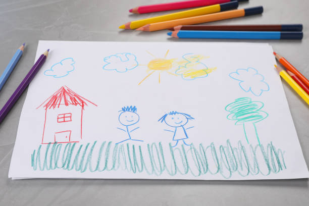 istock Cute child`s drawing and colorful pencils on grey textured table 2204287877