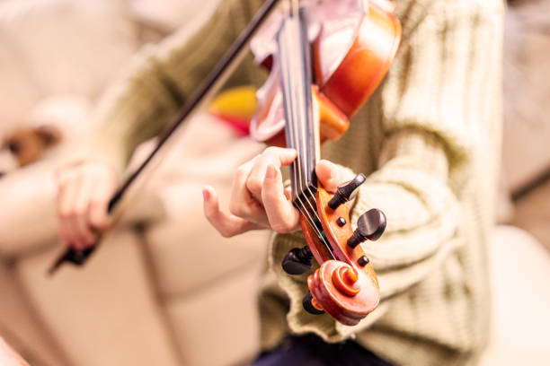 istock girl practicing playing a fast melody on the violin. Hand and finger positioning 2204287915