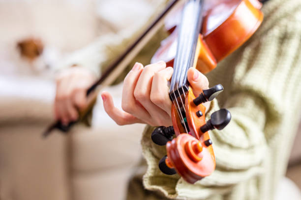 istock playing a new piece on the violin in a music class 2204287935