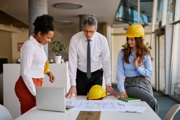 istock Architects and engineers reviewing blueprints in the office 2204288117