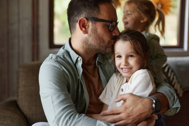 istock Affectionate father spending time with his girls at home. 2204291717