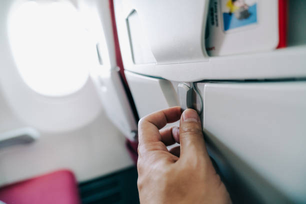 istock Passenger opening an airplane tray table, preparing for a comfortable flight 2204292415