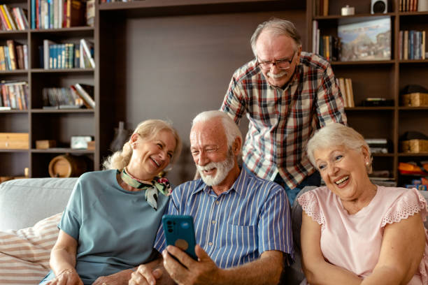 istock Elderly Friends Laughing While Looking at a Smartphone 2204292520