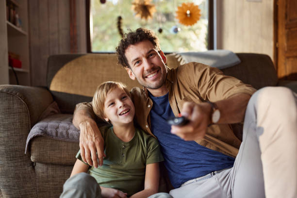 istock Happy single father and son watching TV at home. 2204293685